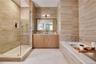 Bathroom featuring tile walls, a stall shower, vanity, a bath, and light tile patterned flooring