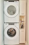 Laundry room featuring stacked washer / drying machine and tile patterned flooring
