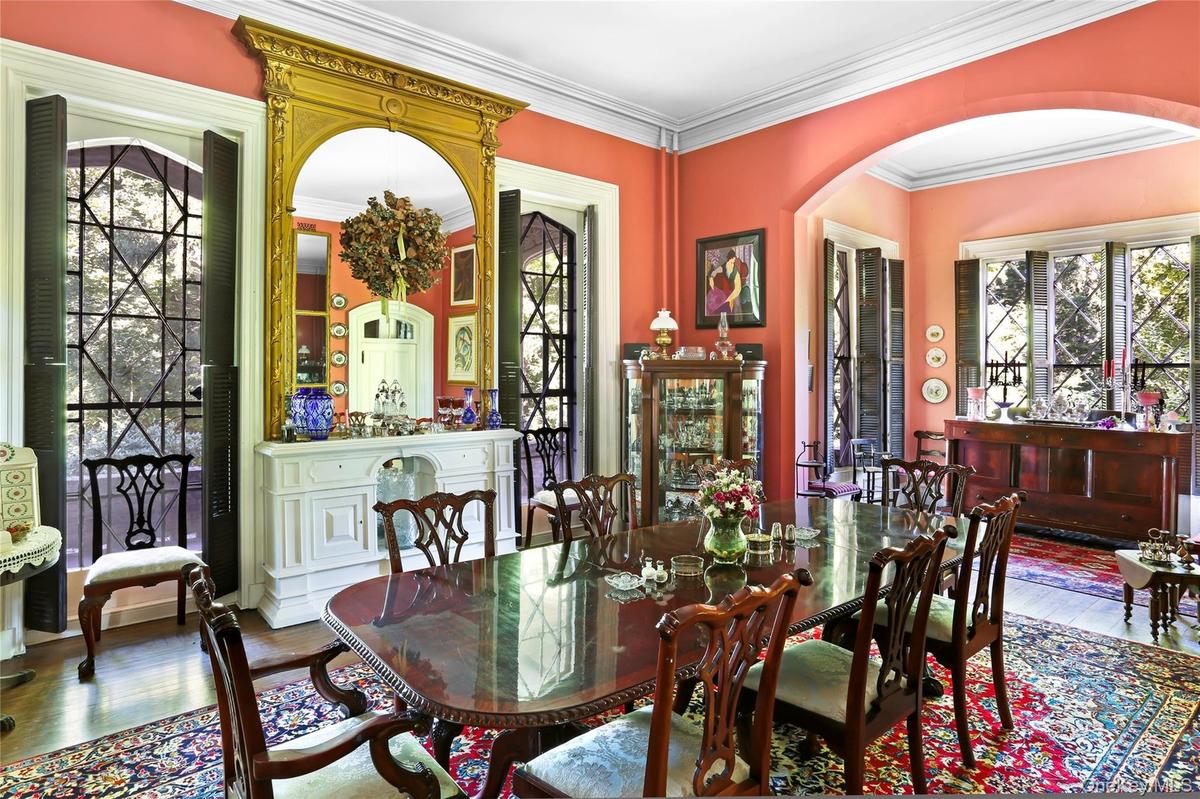 Dining area featuring arched walkways, wood finished floors, and ornamental molding