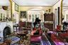 Sitting room featuring arched walkways, crown molding, plenty of natural light, and a fireplace with raised hearth
