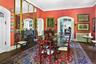 Dining space featuring radiator heating unit, wood finished floors, a fireplace, arched walkways, and crown molding