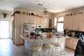 Kitchen with a breakfast bar, light brown cabinets, white appliances, glass insert cabinets, and light tile patterned floors