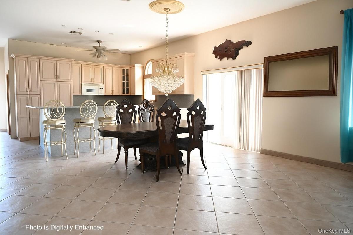 Dining area with a chandelier, light tile patterned flooring, and a ceiling fan