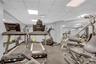 Exercise room featuring a drop ceiling and a wall mounted AC