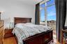 Bedroom with light wood finished floors and a city view