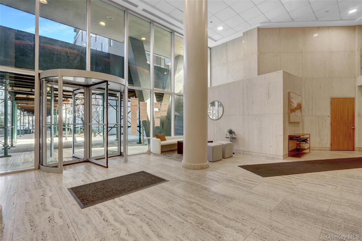 Common area with a towering ceiling, a wall of windows, and recessed lighting