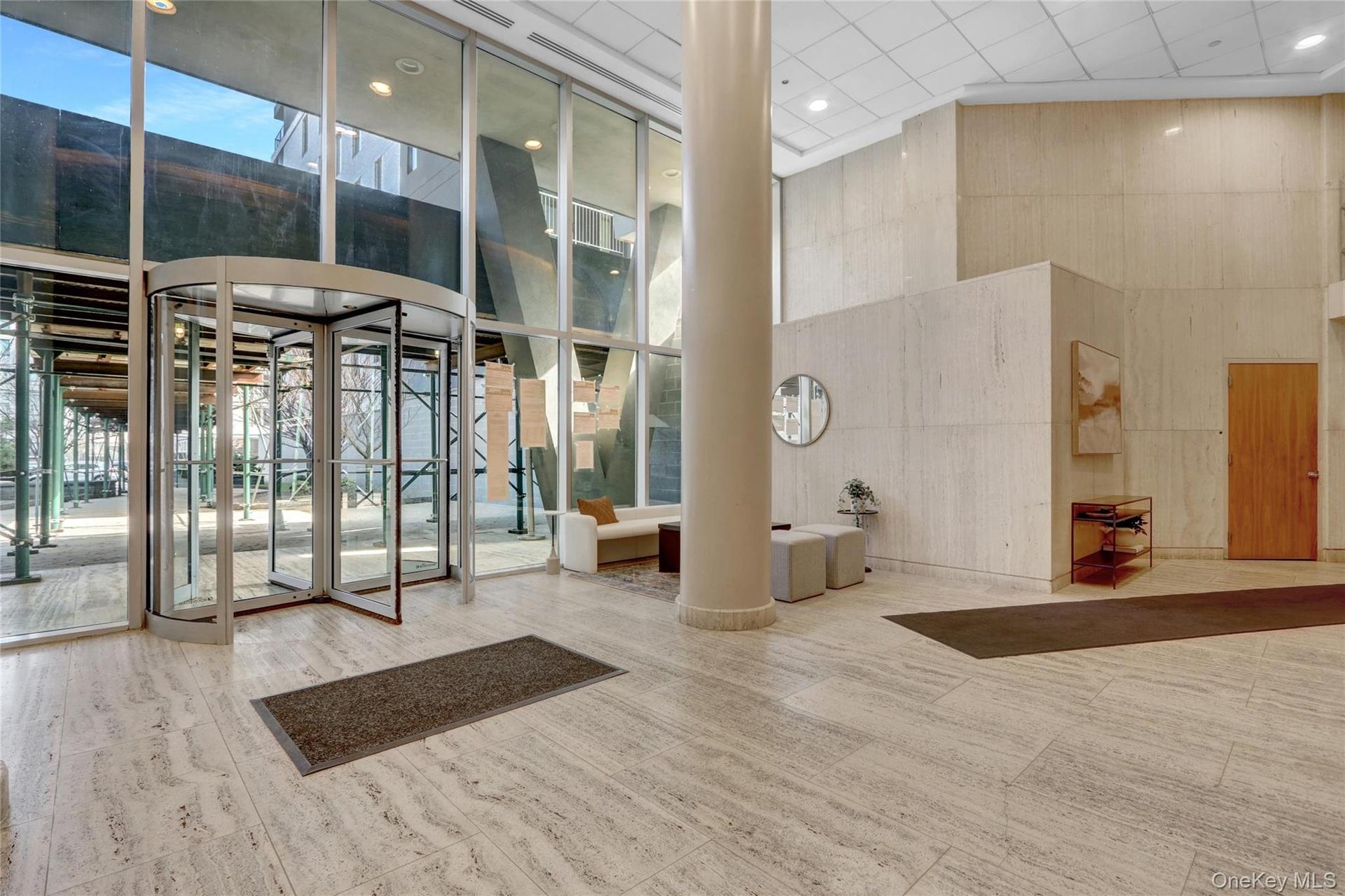 Common area with a towering ceiling, a wall of windows, and recessed lighting