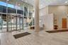 Common area with a towering ceiling, a wall of windows, and recessed lighting