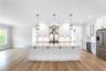 Kitchen featuring stainless steel fridge with ice dispenser, beverage cooler, light countertops, light wood finished floors, and ornamental molding