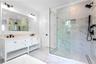 Full bath with a marble finish shower, crown molding, marble finish flooring, double vanity, and plenty of natural light