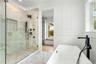 Full bathroom with marble finish flooring, crown molding, a soaking tub, a stall shower, and a decorative wall