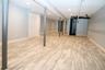 Finished below grade area with light wood-style flooring and recessed lighting