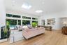 Living room featuring recessed lighting, a towering ceiling, light wood-style flooring, plenty of natural light, and a skylight