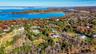 Aerial view of property and surrounding area with a nearby body of water