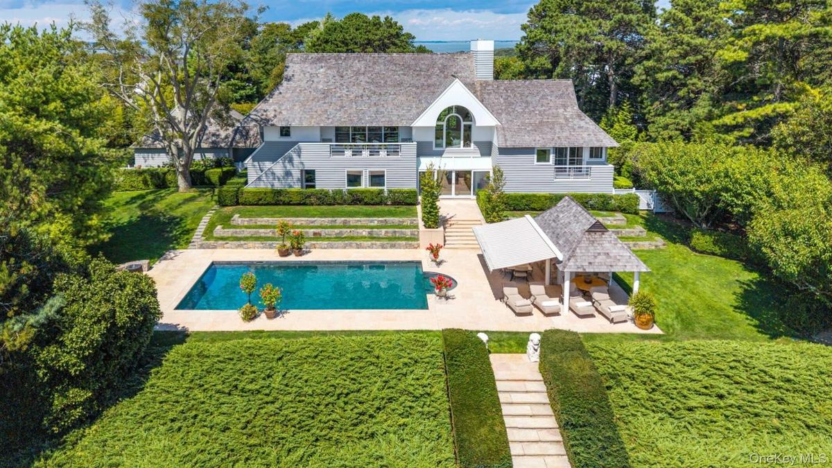 Back of property with a patio area, a balcony, a lawn, a chimney, and an outdoor pool
