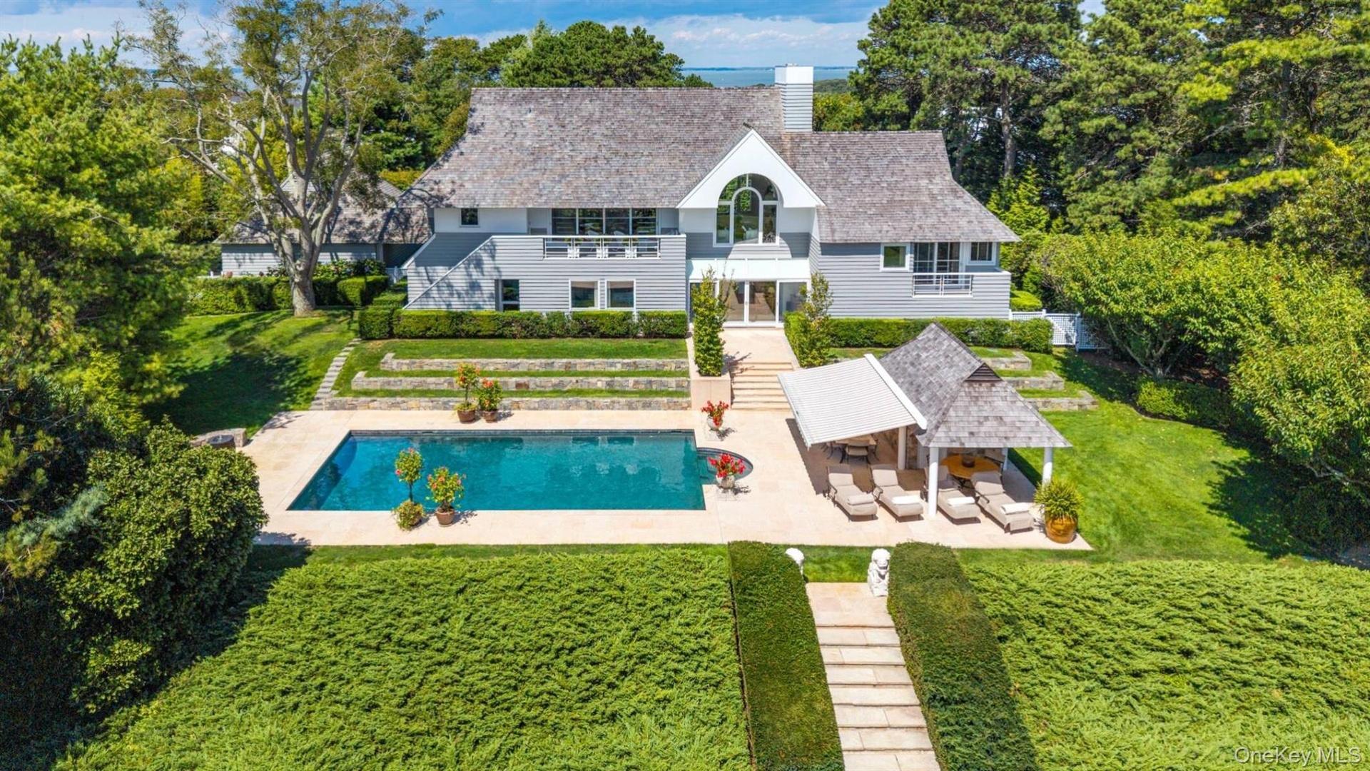 Back of property with a patio area, a balcony, a lawn, a chimney, and an outdoor pool