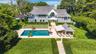 Back of property with a patio area, a balcony, a lawn, a chimney, and an outdoor pool