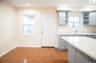 Kitchen featuring a sink, gray cabinets, open shelves, tile patterned floors, and baseboards