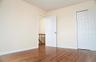Unfurnished bedroom with wood finished floors, a closet, and baseboards