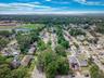 Aerial overview of property's location with nearby suburban area and a tree filled landscape