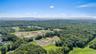 Aerial view of a heavily wooded area and a water and mountain view