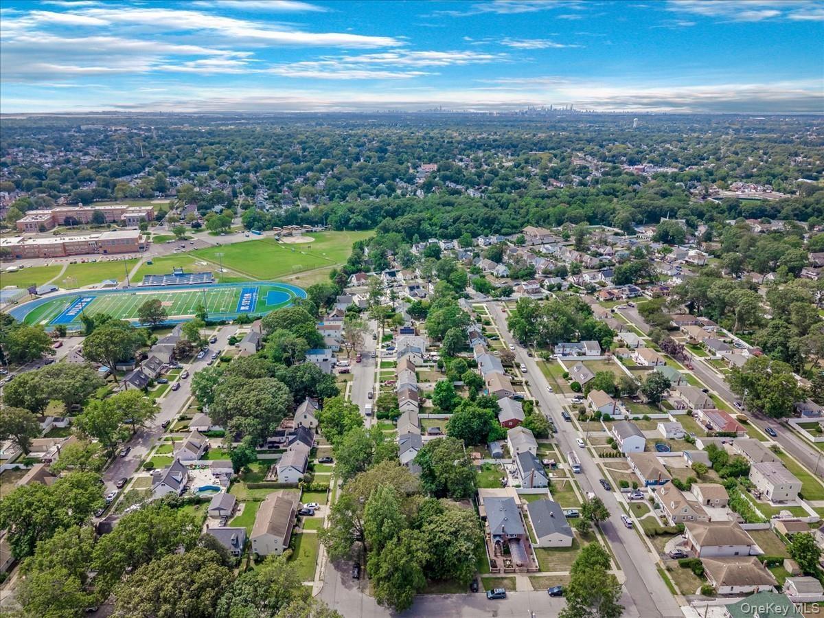 View of property location featuring nearby suburban area and a tree filled landscape