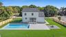 Back of property with a patio, a fire pit, roof with shingles, and a fenced backyard