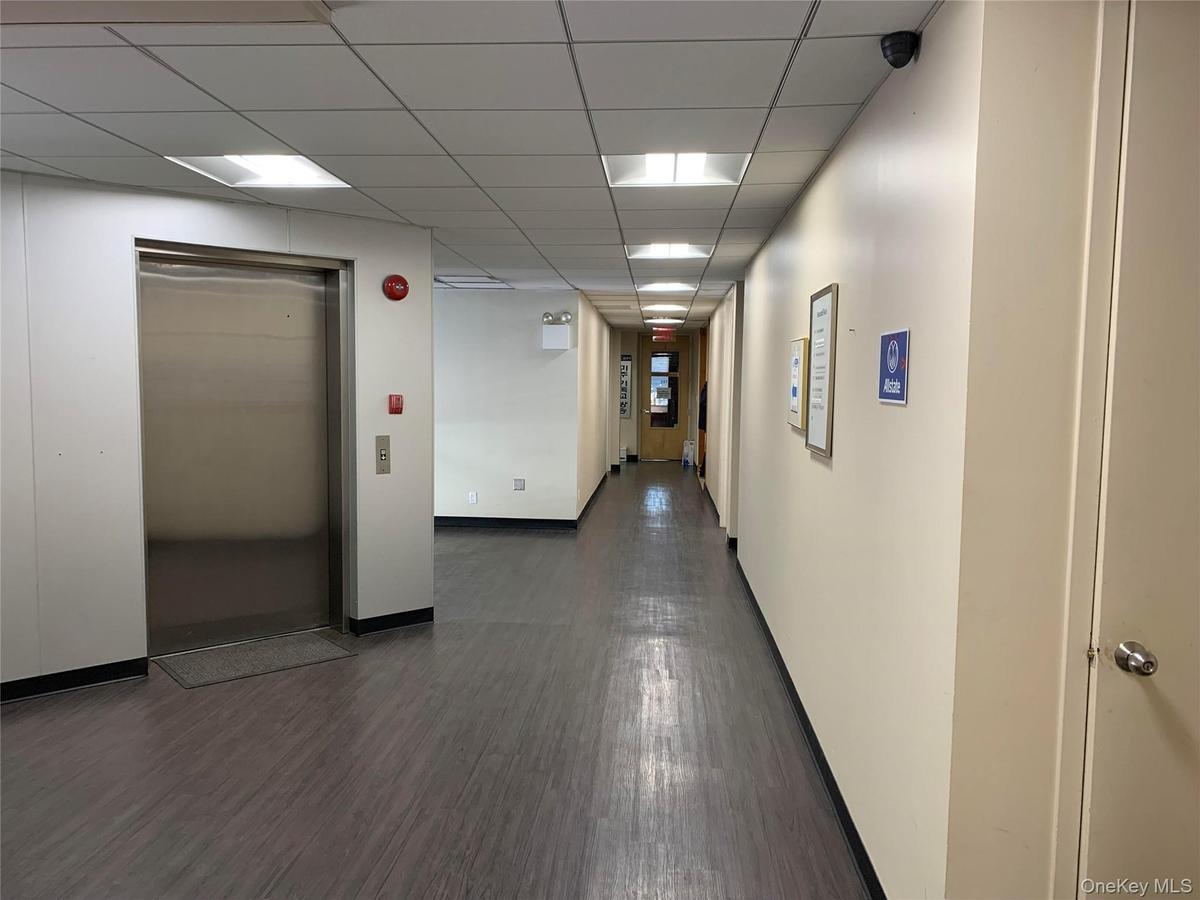 Hallway with dark hardwood / wood-style flooring and elevator