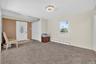 Living area with a baseboard heating unit and carpet flooring
