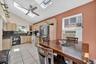 Kitchen with light brown cabinets, a skylight, light tile patterned floors, white appliances, and high vaulted ceiling