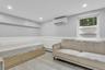 Living area featuring a wall mounted AC, a wainscoted wall, recessed lighting, light marble finish floors, and a baseboard radiator