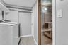 Laundry area featuring washer and clothes dryer, light marble finish flooring, and baseboards