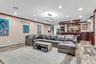 Living room featuring crown molding, light wood-style flooring, recessed lighting, an AC wall unit, and a bar