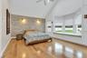 Bedroom with multiple windows, wood finished floors, high vaulted ceiling, and ceiling fan