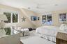 Bedroom with multiple windows, carpet flooring, a ceiling fan, and vaulted ceiling