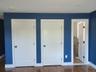 Unfurnished bedroom with dark wood finished floors and two closets
