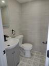 Bathroom with tile walls, vanity, and light tile patterned floors