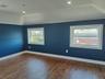 Empty room with dark wood-style floors and recessed lighting