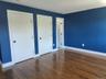 Unfurnished bedroom with dark wood finished floors and multiple closets