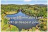 Drone / aerial view of a large body of water and a heavily wooded area