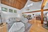 Living room with high vaulted ceiling, wooden ceiling, and light wood-style floors
