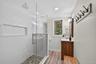 Bathroom featuring vanity, a stall shower, and light wood-style flooring