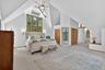 Bedroom featuring carpet, high vaulted ceiling, two closets, and a wall unit AC
