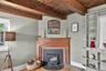 Detailed view of beam ceiling, wood finished floors and a fireplace