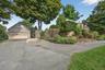 View of front of house featuring stone siding, a garage, and driveway