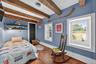 Bedroom with beamed ceiling and hardwood / wood-style flooring