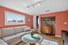 Family room with track lighting, light wood-style flooring, and stairway
