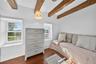 Bedroom with beamed ceiling and wood finished floors