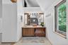 Bathroom featuring healthy amount of natural light, vanity, lofted ceiling, and light tile patterned floors