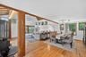 Dining space with light wood-style flooring, high vaulted ceiling, an AC wall unit, and beamed ceiling